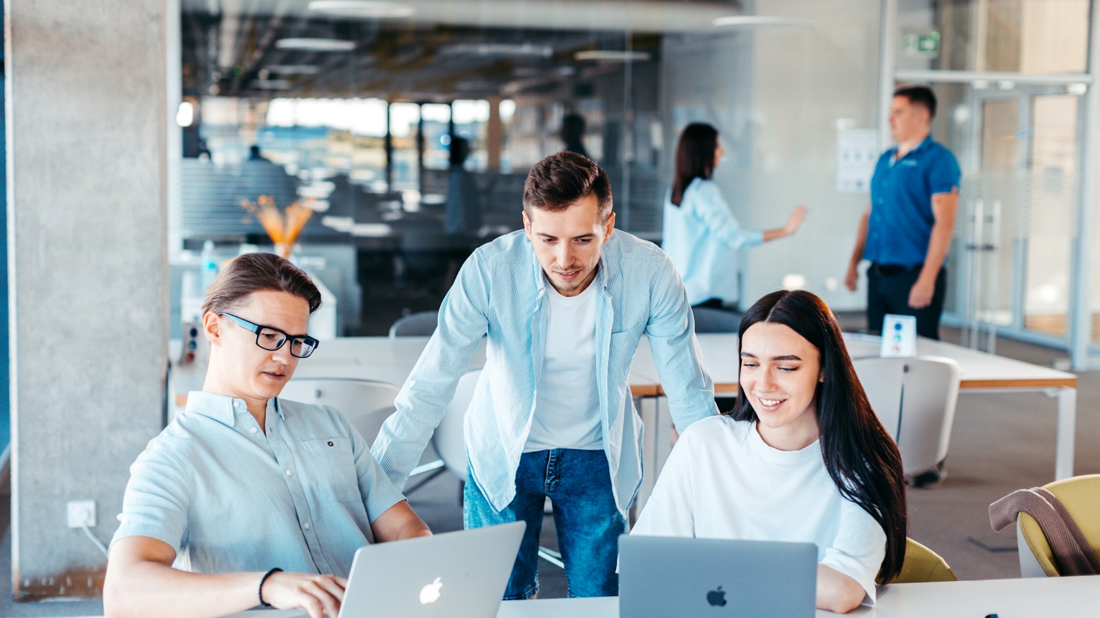 Young professionals discussing plans around a laptop at an IT startup meeting