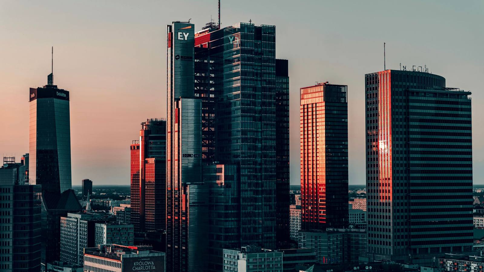 Modern office towers in Warsaw at dusk.