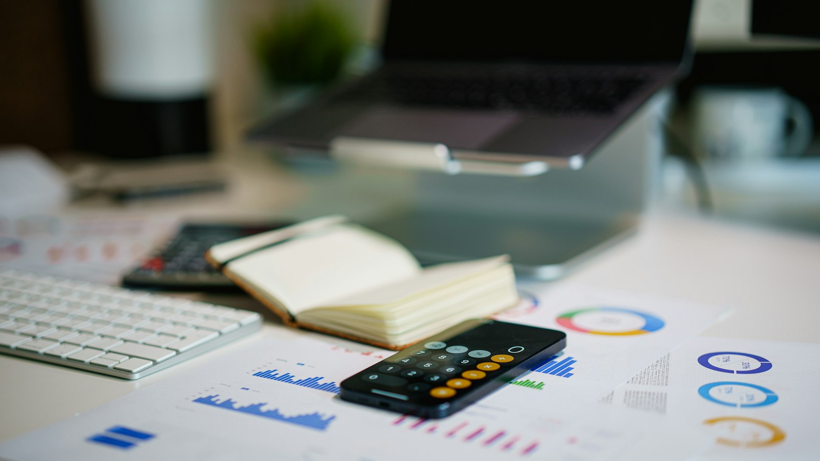 An office desk with a smartphone and printed financial charts