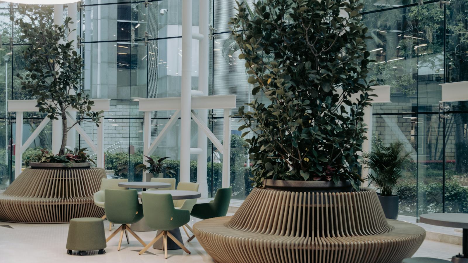 A bright modern office lobby with a table, chairs and potted plants