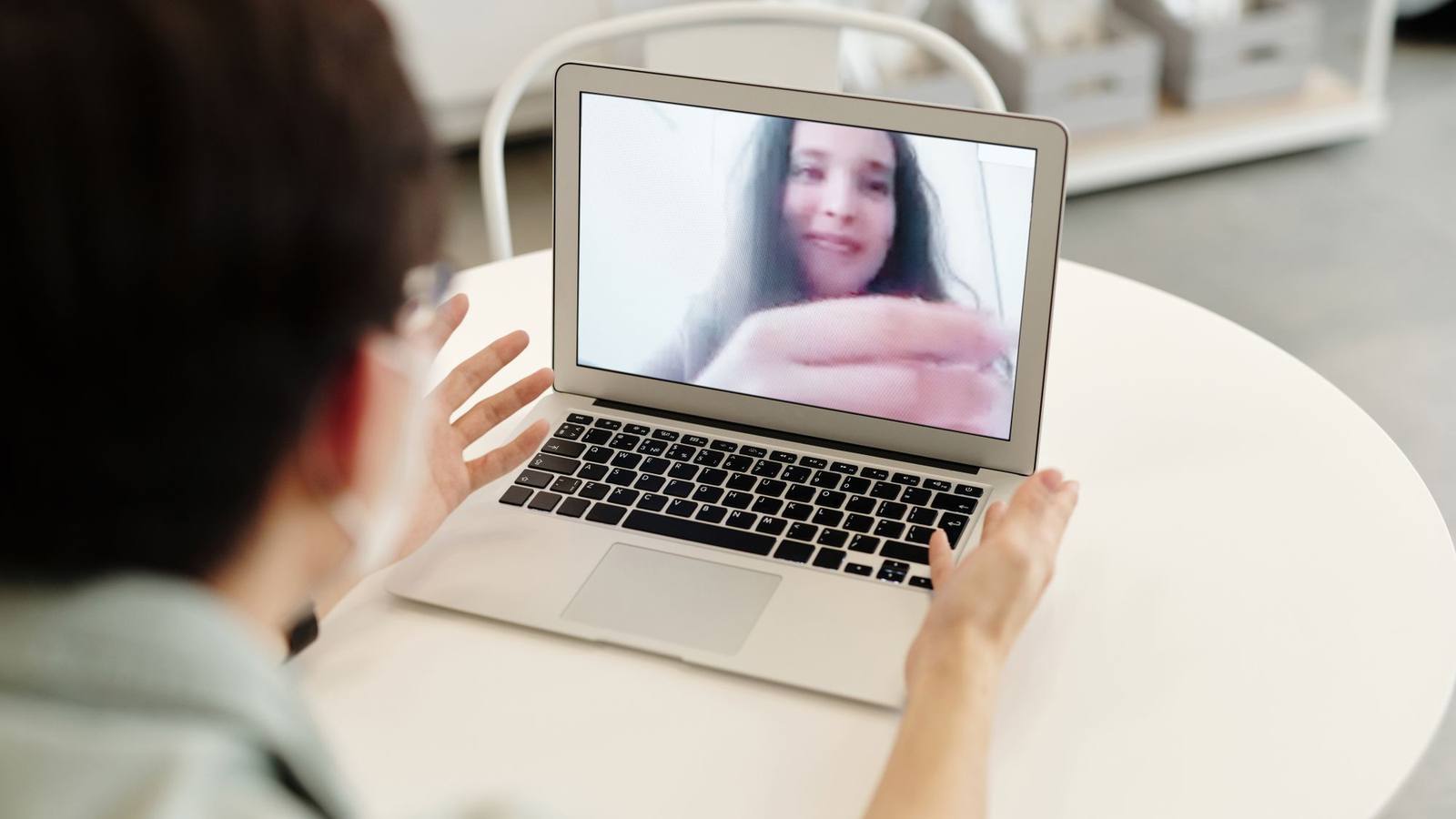 A person taking part in a video call on a laptop indoors.